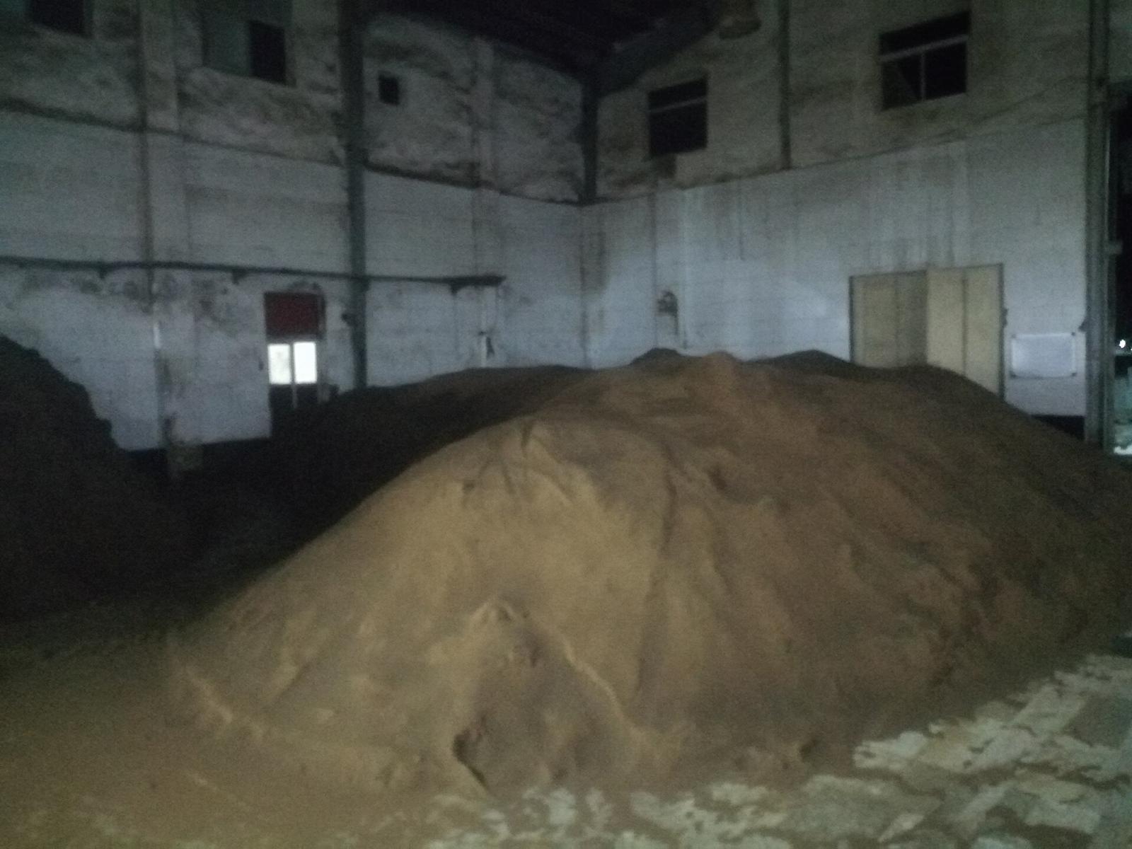 A large heap of feed raw material stored in a warehouse